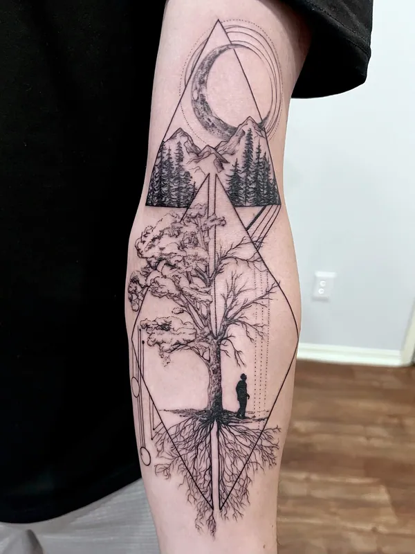 Black-and-grey geometric tattoo of a crescent moon, mountains, a rooted tree and a small figure inside stacked diamonds on a forearm