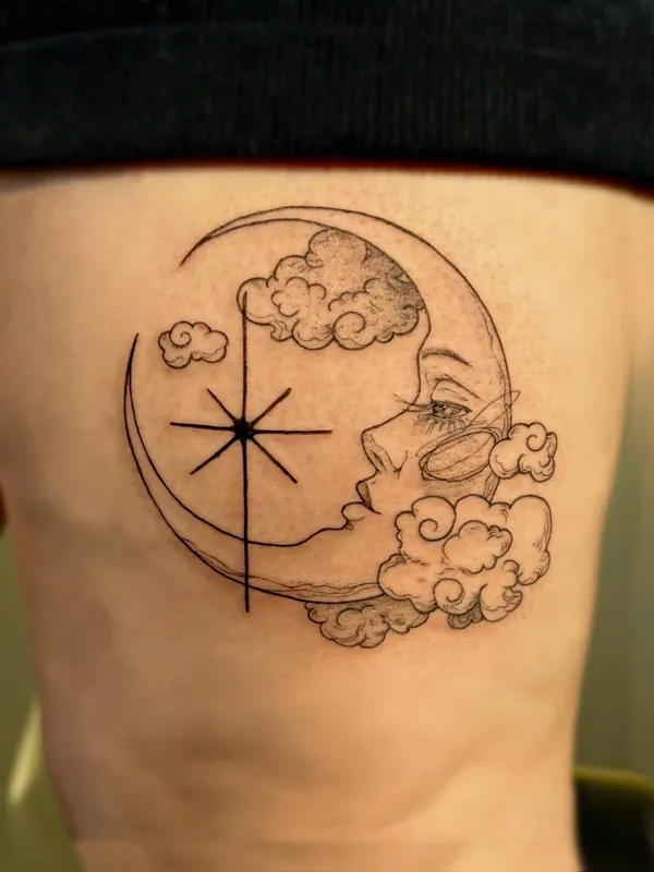 Fine-line tattoo of a crescent moon with a sleeping face, a star and small clouds on a thigh