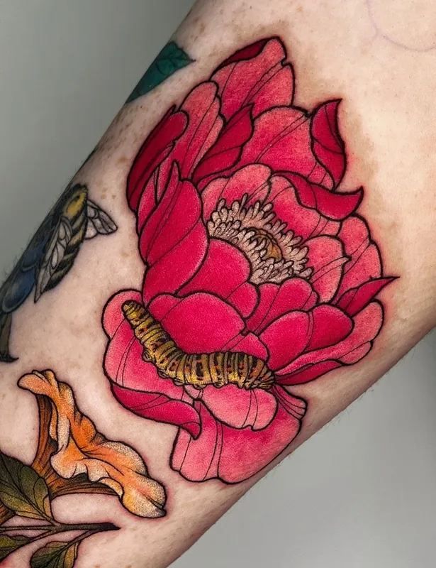Color neo-traditional red peony tattoo with a striped caterpillar on its lower petal on a forearm