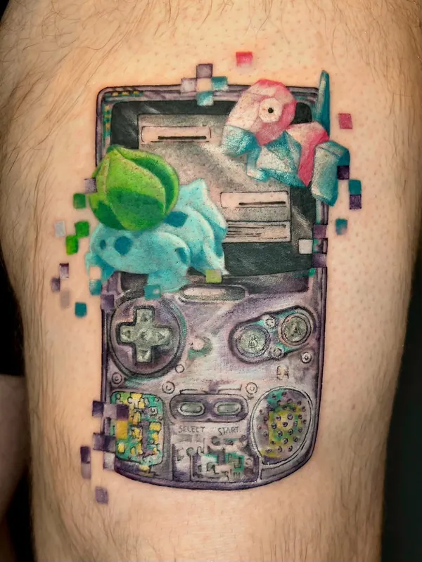 Color tattoo of a Game Boy Color with Bulbasaur, Squirtle and Porygon breaking out in glitch pixels on a thigh