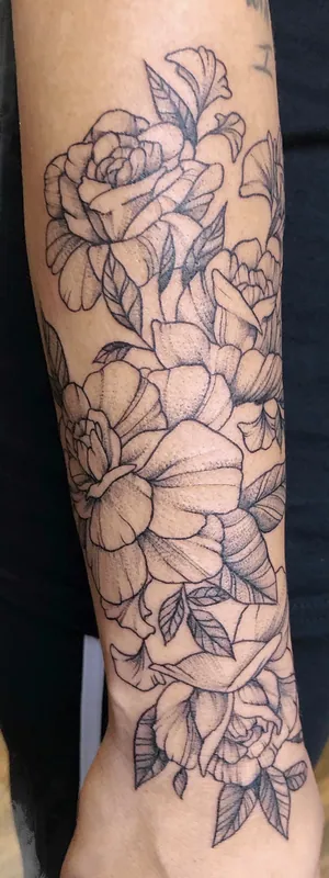 Black-and-grey fine-line tattoo of roses and peonies with leaves wrapping a forearm