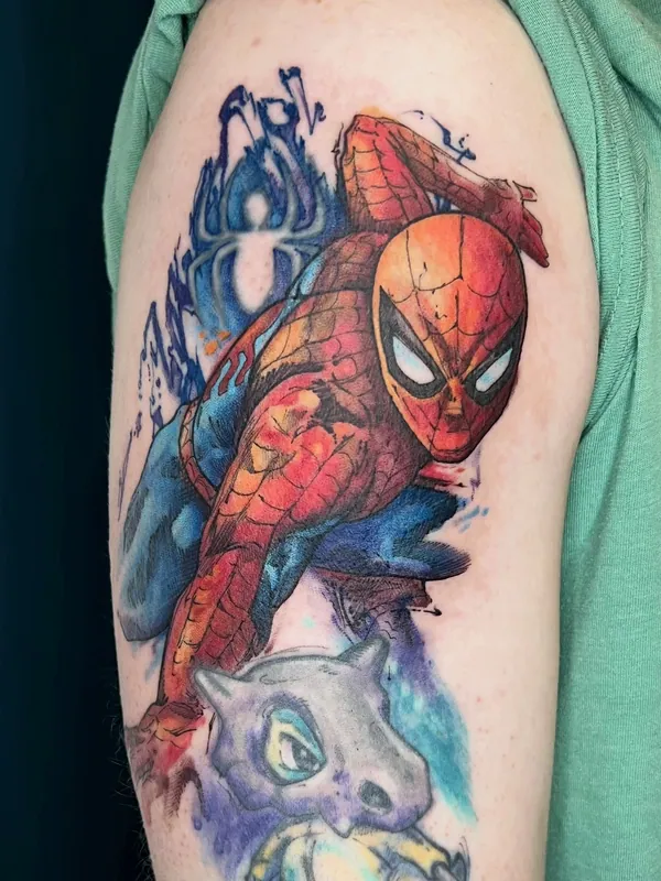Color watercolor-style Spider-Man tattoo crouching above a Cubone from Pokemon on an upper arm