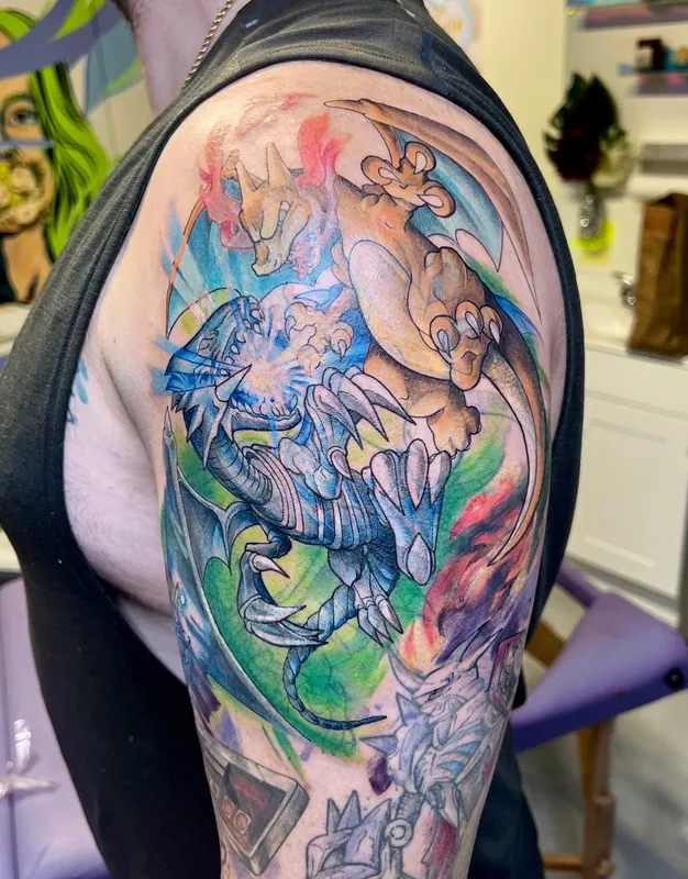 Color watercolor-style tattoo of Charizard clashing with the Blue-Eyes White Dragon on a shoulder and upper arm