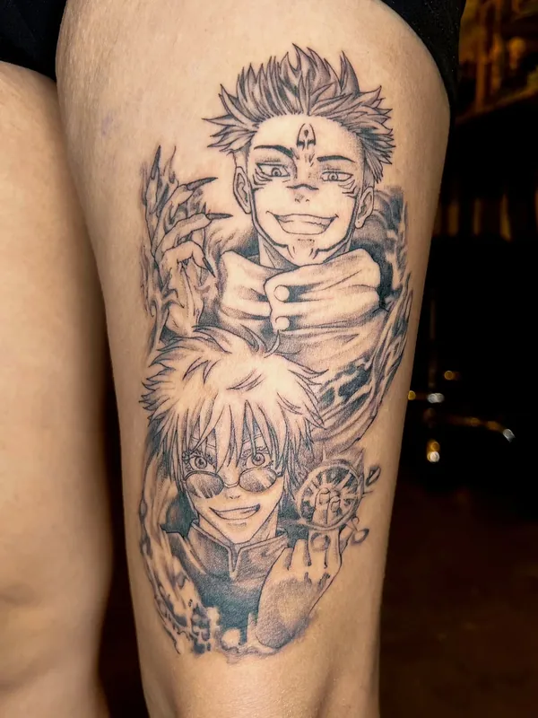 Black-and-grey anime tattoo of Sukuna grinning above Gojo from Jujutsu Kaisen on a thigh